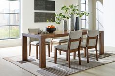 a dining room table with chairs and vases on it