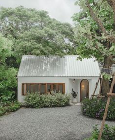 a white house surrounded by greenery and trees