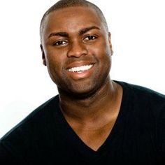 a man in black shirt smiling at the camera