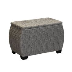 a gray wicker ottoman with black legs and a cushion on the top, sitting in front of a white background