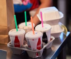 six plastic cups with straws in them sitting on a tray