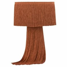 an orange lamp with long fringes on the base and a light shade over it