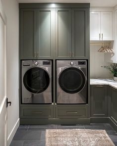 a large washer and dryer in a small room with cabinets on either side