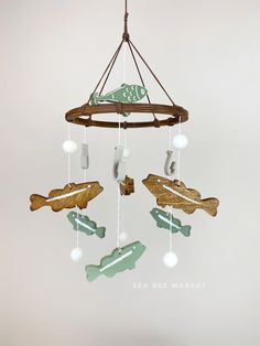 a wind chime hanging from a ceiling in the shape of fish and boat shapes