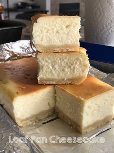 four pieces of cheesecake sitting on top of aluminum foil