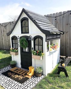 a small white and black house with potted plants