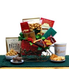 a basket filled with lots of food next to two coffee mugs and other items