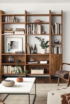 a living room filled with furniture and bookshelves next to a wall mounted book shelf