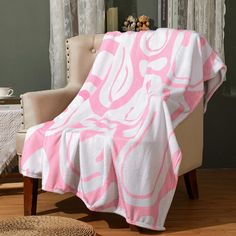 a pink and white blanket sitting on top of a chair