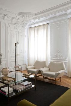 an elegant living room with white walls and wood flooring is furnished with modern furniture