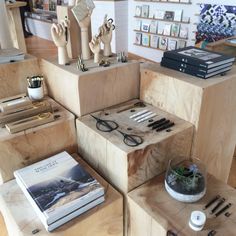 several wooden boxes stacked on top of each other in a room with pictures and books