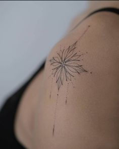 the back of a woman's shoulder with a flower tattoo on her left side