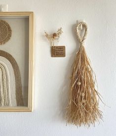 two pieces of woven art hanging on the wall next to a framed piece of artwork