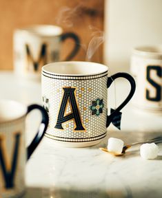 a coffee mug sitting on top of a counter next to marshmallows