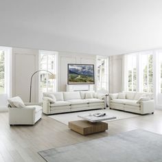 a living room with white furniture and large windows