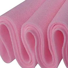 four pink sponge cloths stacked on top of each other, with one being rolled up