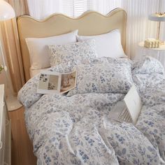 an open laptop computer sitting on top of a bed covered in blue and white sheets