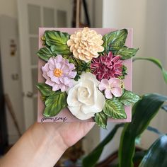 a hand holding a card with flowers on it