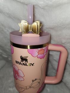 a pink starbucks cup with a gold bow on top