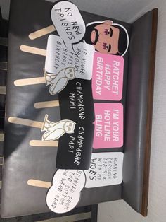 the sign is made out of popsicle sticks and has pictures of people on them