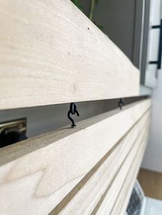 a close up of a drawer with some small black figures on the drawers and handles