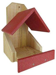 a wooden bird house with red roof