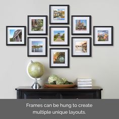 a bunch of frames hanging on the wall above a table with fruit and vegetables in front of it