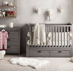 a baby's room is decorated in gray and white with red decorations on the wall