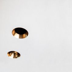 two gold colored knobs on the side of a white wall