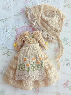 an old fashioned dress and bonnet are sitting on a table