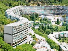 an aerial view of a circular building surrounded by trees and buildings in the middle of it