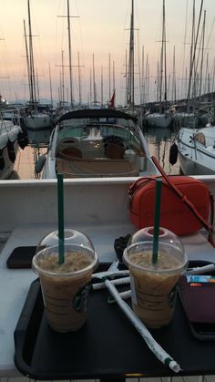 two drinks sitting on top of a table next to boats