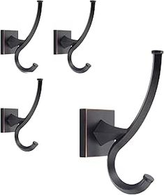 three black wrought iron wall hooks on a white background