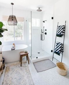 a bathroom with a tub, shower and rugs on the floor in front of it