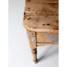 an old wooden table with peeling paint on the top and bottom edge, against a white background