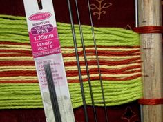 two knitting needles are next to each other