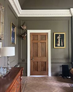 a room with a wooden door and pictures on the wall