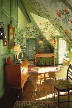 an attic bedroom with green walls and floral wallpaper on the ceiling, along with wooden furniture