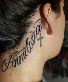 a woman's neck with the word tattoo on her left side behind her ear