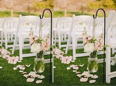 two vases filled with flowers sitting next to each other on top of a grass covered field