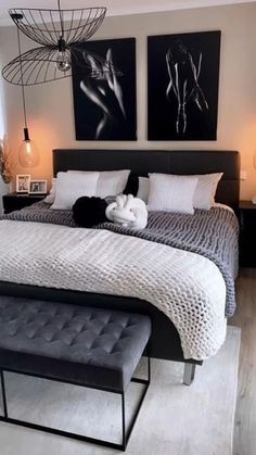 a bedroom with two paintings above the bed