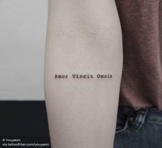 a person with a tattoo on their arm that reads, amr vintch omnia