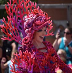 a woman with pink hair and red corals on her head