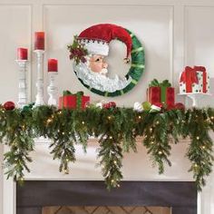 a mantel decorated with greenery and christmas decorations