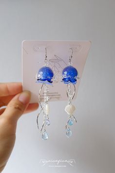 "---- Welcome to CiaoQiao Shop ----- Find more jellyfish in different styles from whole collection: https://www.etsy.com/shop/CiaoQiaoShop?ref=seller-platform-mcnav&section_id=47654964 This piece captures the serene and graceful movement of these sea creatures, complete with cascading tendrils that sway gently with your every step. The dangle design allows for a playful movement, reminiscent of a jellyfish's dance through the water.  Designed for ocean lovers and those who adore whimsical, beach Water Themed Accessories, Jellyfish Earrings Diy, Ocean Themed Jewelry, Whimsical Jellyfish, Sea Themed Earrings, Sea Creature Jewelry, Ocean Accessories, Jellyfish Jewelry, Jellyfish Earrings