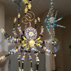 a close up of a glass window with beads and chains hanging from it's center