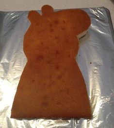 a piece of cake that is shaped to look like a woman's body on aluminum foil