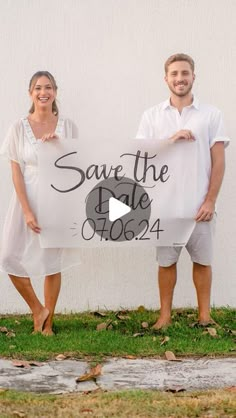 a man and woman holding a save the date sign