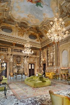 an ornately decorated living room with chandeliers and couches in gold tones