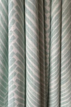 a curtain with wavy lines on it in green and white colors, close up view